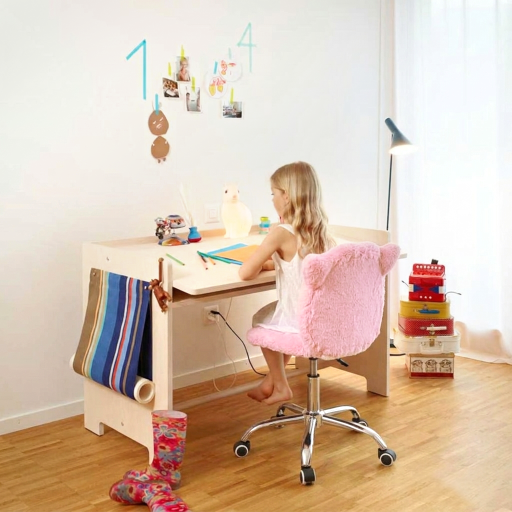 Child sitting at a desk with a pink chair in a bright room